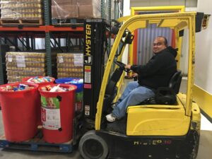David moving food barrels on forklift