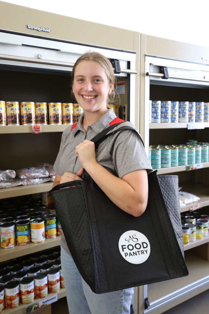 Student holding AS Food Pantry bag.