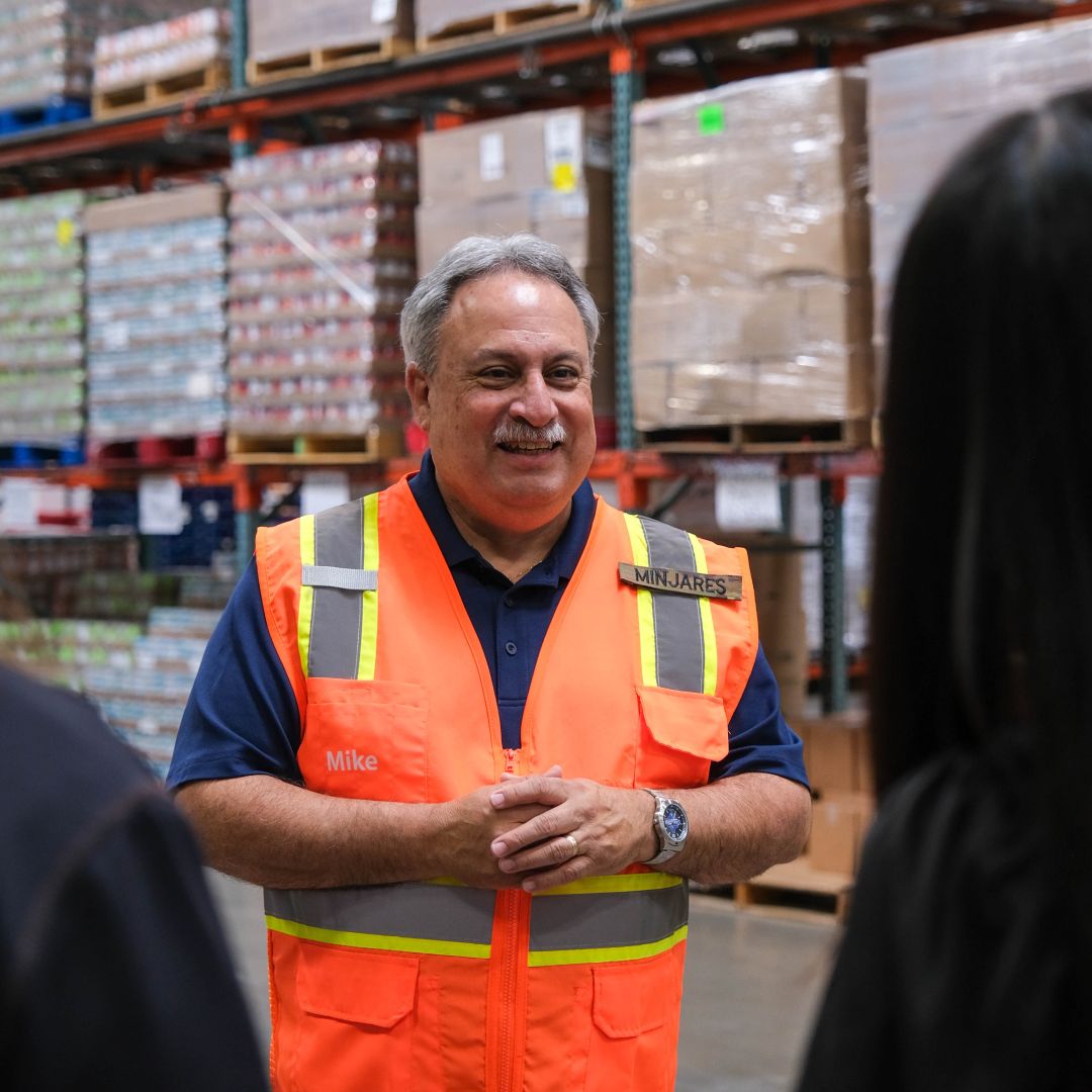 Food Bank staff member leading a tour in the warehouse.