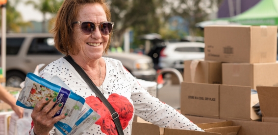 Volunteer giving out food at a food distribution