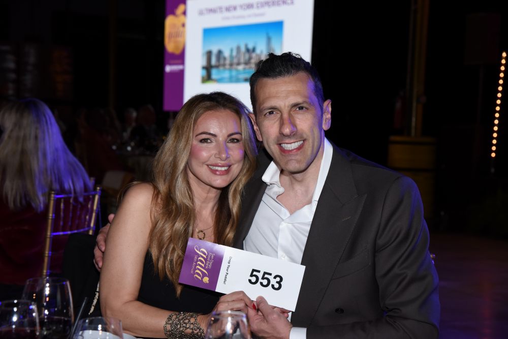 A couple holding up their bidder number.