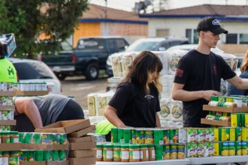 Volunteers arrange boxes of nonperishable items at a local food distribution.