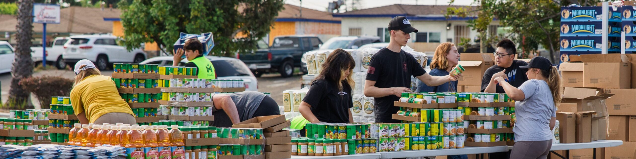 Volunteers arrange boxes of nonperishable items at a local food distribution.