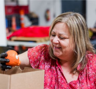 Volunteer in our warehouse inspecting oranges.