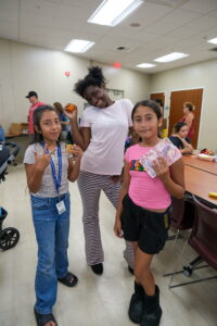 Three girls enjoy food received from the San Diego Food Bank's Skyline Hills Library distribution.